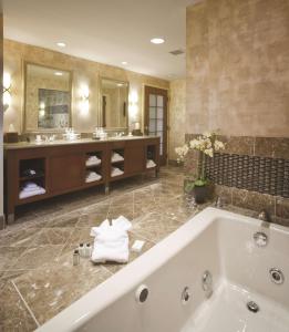 a large bathroom with a tub and two sinks at Embassy Suites by Hilton Norman Hotel & Conference Center in Norman