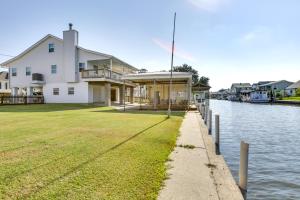 a large white house next to a body of water at Bayou Bliss Barataria Waterfront Getaway with Dock! in Barataria