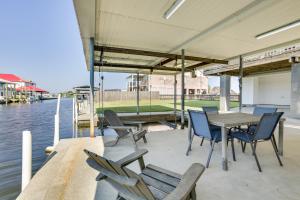 a table and chairs on a dock next to the water at Bayou Bliss Barataria Waterfront Getaway with Dock! in Barataria