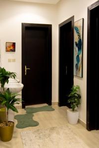 a bathroom with two black doors and two potted plants at دور أرضي بتصميم فاخر دخول ذاتي in Riyadh