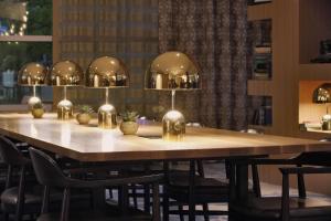 einen Tisch in einem Zimmer mit Stühlen und Beleuchtung in der Unterkunft Hilton Omaha in Omaha
