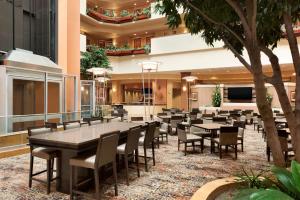 a restaurant with tables and chairs in a building at Embassy Suites Omaha- La Vista/ Hotel & Conference Center in La Vista