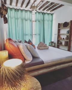 a bed with pillows on it in a room at Olamanga Beach Villa in Jambiani