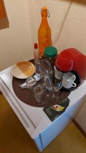 ein Regal im Kühlschrank mit Geschirr und einer Flasche in der Unterkunft IbitiAnJo - Suítes in Conceição da Ibitipoca