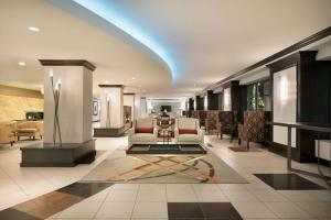 a lobby with chairs and a table in a building at Hilton Orrington/Evanston in Evanston