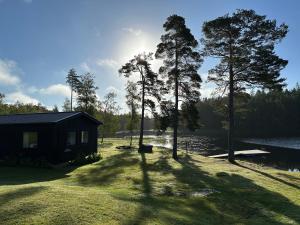eine kleine Hütte am Ufer eines Sees in der Unterkunft Gråbogården event and conference center in Gråbo
