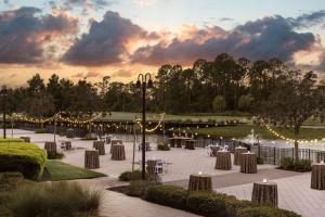 eine Terrasse mit Tischen und Lichtern in einem Park in der Unterkunft Waldorf Astoria Orlando in Orlando