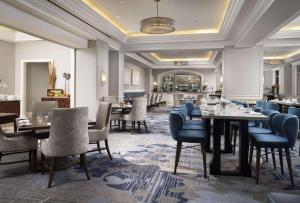 um restaurante com mesas e cadeiras num quarto em Waldorf Astoria Orlando em Orlando