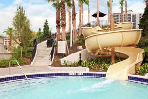 a slide in a pool at a resort with palm trees at Signia by Hilton Orlando Bonnet Creek in Orlando