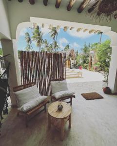 a living room with two chairs and a table at Olamanga Beach Villa in Jambiani