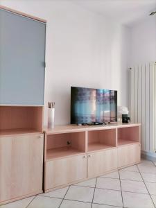 sala de estar con TV en un centro de entretenimiento de madera en Appartamento Solaris 200 m dal mare en San Salvo