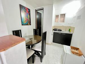 a kitchen with a dining table and a kitchen with a sink at Apartaestudio para 5 personas en el centro Pereira in Pereira