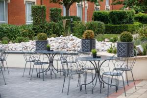 un grupo de mesas y sillas en un patio en Hilton Northampton Hotel en Northampton