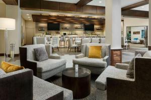 a lobby with chairs and a bar in the background at Hilton Garden Inn Palo Alto in Palo Alto