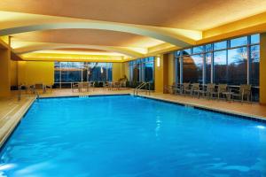 a large swimming pool with blue water in a building at Embassy Suites by Hilton Hampton Convention Center in Hampton