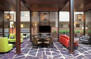 a lobby with a table and chairs and a television at Embassy Suites by Hilton Philadelphia Airport in Philadelphia
