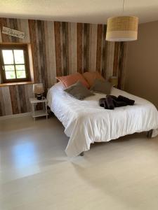 a bedroom with a large bed with white sheets at Domaine des deux sapins in Voillecomte
