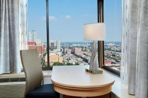 a desk with a lamp and a chair in front of a window at DoubleTree by Hilton Hotel Philadelphia Center City in Philadelphia