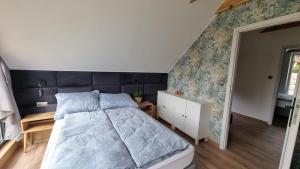 una camera con letto e piumone blu di #NadJeziorem - Domki wypoczynkowe - Jeziorowskie a Jeziorowskie