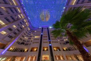 布拉格的住宿－布拉格希爾頓酒店，一座拥有蓝色天花板和棕榈树的大型建筑