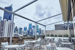 a patio with tables and chairs and a city skyline at Waldorf Astoria Panama in Panama City