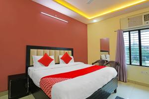 - une chambre avec un grand lit aux murs rouges dans l'établissement OYO Flagship Hotel Abhinandan, à Kanpur