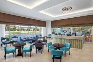 een restaurant met tafels en stoelen en een bar bij DoubleTree by Hilton Ras Al Khaimah in Ras al Khaimah
