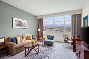 a living room with a couch and a large window at DoubleTree by Hilton Ras Al Khaimah in Ras al Khaimah