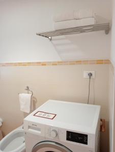 a washing machine in a bathroom with a toilet at Appartamento Aurora in Verbania