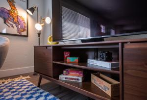 una habitación con una estantería de libros con TV. en The Yellow Door Denver - Mid Century Design, Game Room, and Wood Spa - Near Downtown Denver, en Denver