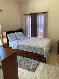 1 dormitorio con cama, escritorio y ventana en SkylineSuites Lost in Paradise - FA4, en Grand Anse