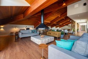 una sala de estar de planta abierta con techos de madera y chimenea en Wanderlust Experience Hotel BW Signature Collection OFICIAL en Campos do Jordão