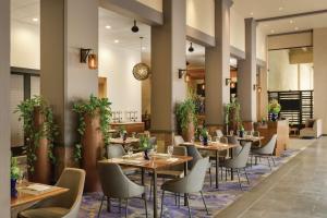 Hilton Scottsdale Resort & Villas في سكوتسديل: مطعم بالطاولات والكراسي والنباتات