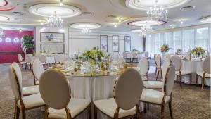 a banquet room with tables and chairs and chandeliers at Hilton Sibiu in Sibiu