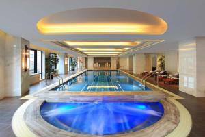 a large swimming pool in a hotel lobby at Waldorf Astoria Shanghai on the Bund in Shanghai