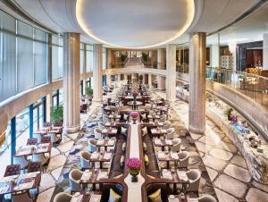 a restaurant with tables and chairs in a building at Waldorf Astoria Shanghai on the Bund in Shanghai