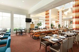 a restaurant with tables and chairs and a flat screen tv at Hilton Garden Inn San Jose/Milpitas in Milpitas