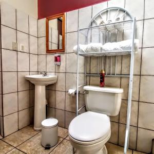 a bathroom with a toilet and a sink at Casa Cafetal Aeropuerto in Alajuela