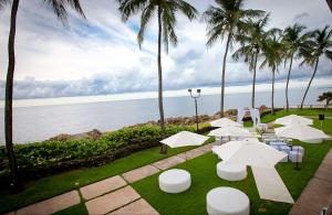 a patio with white tables and chairs and palm trees at The Condado Plaza Hilton in San Juan