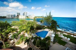 una vista aérea de un complejo con piscina y el océano en The Condado Plaza Hilton en San Juan