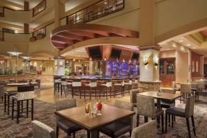 un restaurante con mesas y sillas y un bar en Embassy Suites by Hilton San Marcos Hotel Conference Center en San Marcos
