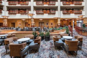 um átrio de um hotel com mesas e cadeiras em Embassy Suites by Hilton Saint Louis Saint Charles em St. Charles