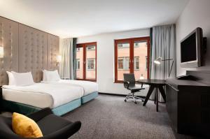 um quarto de hotel com uma cama e uma secretária em Hilton Stockholm Slussen Hotel em Estocolmo