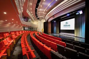 un teatro vacío con asientos rojos y una pantalla en Hilton Stockholm Slussen Hotel, en Estocolmo