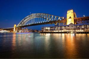 un pont sur une masse d'eau la nuit dans l'établissement Hilton Sydney, à Sydney