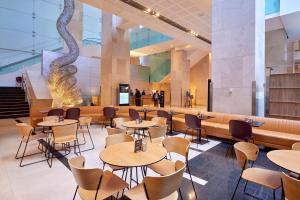 a restaurant with tables and chairs in a building at Hilton Sydney in Sydney