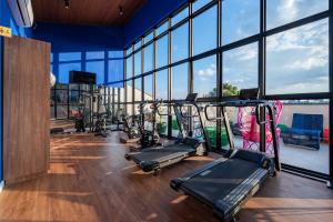 a gym with several tread machines in a room with windows at Wanderlust Experience Hotel BW Signature Collection OFICIAL in Campos do Jordão
