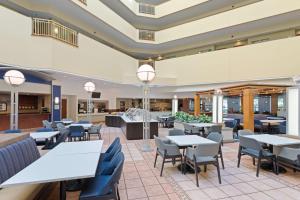 a restaurant with tables and chairs in a cafeteria at Embassy Suites by Hilton Tampa USF Near Busch Gardens in Tampa