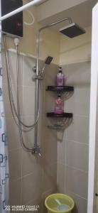a bathroom with a shower with a toilet and shelves at Pasay Coast Residences JCMJ in Manila