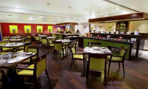 a restaurant with tables and chairs and a bar at Hilton Garden Inn, Trivandrum in Trivandrum